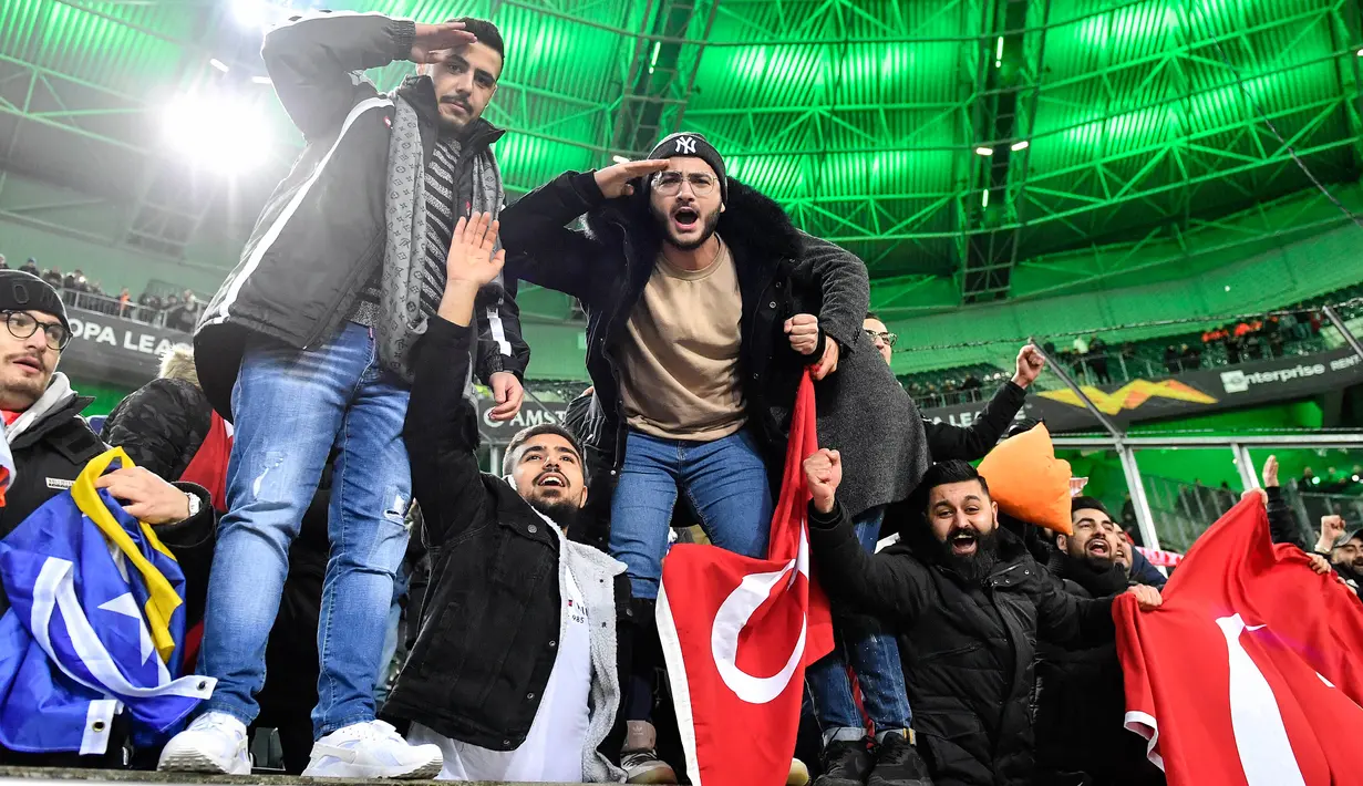 Suporter Turki memberi hormat saat merayakan kemenangan Istanbul Basaksehir atas  Borussia Moenchengladbach pada laga Grup J Liga Europa di Moenchengladbach, Jerman, Kamis (12/12/2019). Moenchengladbach gagal ke fase gugur setelah kalah 1-2 dari Basaksehir. (AP Photo/Martin Meissner)