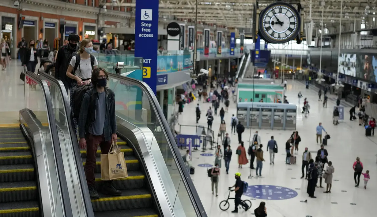 Orang-orang memakai masker pada jam sibuk pagi hari di stasiun kereta Waterloo di London, Rabu (13/7/2021). Wali Kota Sadiq Khan menekankan transportasi publik di London akan terus memberlakukan kewajiban memakai masker meskipun Inggris melonggarkan pembatasan Covid-19. (AP Photo/Matt Dunham)