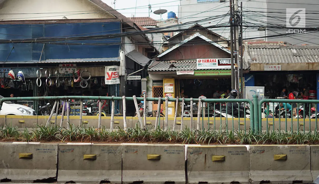 Kondisi pagar pembatas jalur transjakarta yang ditopang bambu di Jalan Otista Raya, Jakarta, Jumat (5/7/2019). Meskipun telah lama rusak, pagar besi berjeruji yang berfungsi sebagai pembatas agar orang tidak menyeberang secara sembarangan itu belum juga diperbaiki. (Liputan6.com/Immanuel Antonius)