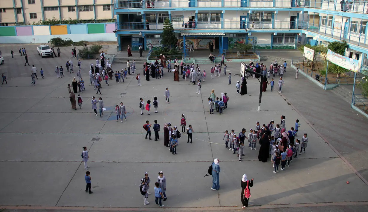 Para siswa masuk sekolah pada hari pertama tahun ajaran baru di kamp pengungsi Shati, Gaza City, Palestina, 8 Agustus 2020. Siswa Palestina dari Jalur Gaza memulai tahun ajaran baru setelah sekolah ditutup selama lima bulan karena COVID-19. (Xinhua/Rizek Abdeljawad)