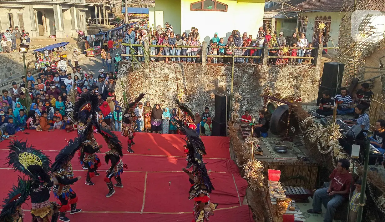 Warga menyaksikan aksi tarian kuda lumping para penari komunitas lima gunung di Desa Mantran Wetan, Kabupaten Magelang, Jumat  (11/10/2019). Pertunjukan ini bagian dari Perayaan Saparan sebagai wujud syukur warga di desa itu. (Liputan6.com/Gholib)