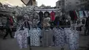 Pedagang kaki lima Palestina memajang pakaian untuk dijual di samping puing-puing bangunan di Kota Gaza, Minggu (18/7/2021). Bagi warga Palestina yang kehilangan orang-orang terkasih dalam pertempuran antara militan Gaza dan Israel, tidak ada alasan untuk merayakan Idul Adha. (AP Photo/Khalil Hamra)