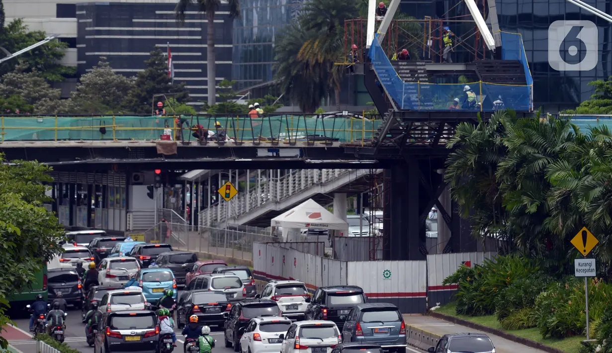 Suasana lalu lintas sekitar proyek Tugu Tenaga Kesehatan di Jembatan Penyeberangan Orang (JPO) Sudirman, Jakarta, Jumat (12/11/2021). Tugu Tenaga Kesehatan dibangun di atas JPO Sudirman. (merdeka.com/Imam Buhori)
