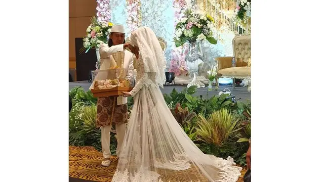 Saat menyerahkan seserahan, Irene mencium tangan sang suami.