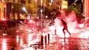 Amarah Lebanon Tolak Kabinet Baru: Demonstran antipemerintah melemparkan petasan ke arah polisi antihuru-hara saat demonstrasi menentang pemerintahan baru di dekat Parliament Square, Beirut, Rabu (22/1/2020). (AP/Hussein Malla)