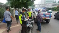 Polisi saat menindak pengendara sepeda motor yang melawan arus. (TMC Polda Metro Jaya)