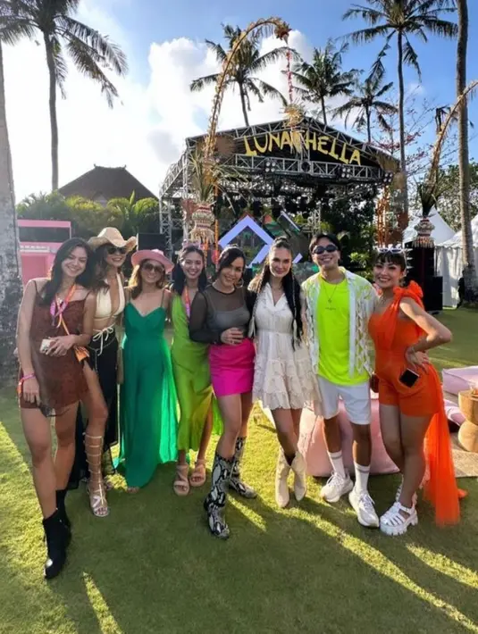 Ayu Dewi tampil fresh dengan one shoulder jumpsuit miliknya yang berwarna oranye,