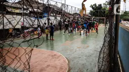 Suasana latihan sepak bola di lapangan samping Banjir Kanal Barat (BKB), Jakarta, Kamis (7/1/2020). Revitalisasi jalur hijau di sepanjang aliran BKB menyulap kawasan kumuh menjadi tempat interaktif warga sekitar yang dilengkapi fasilitas bermain, seperti lapangan futsal. (Liputan6.com/Johan Tallo)