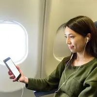 Mengakses Vidio saat dalam perjalanan di pesawat/copyright shutterstock/leungchopan