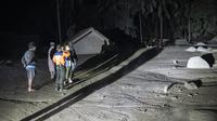 Warga dan tim penyelamat memeriksa area yang tertutup abu vulkanik dalam upaya mencari korban atau jenazah pasca erupsi Gunung Semeru di Desa Sumber Wuluh, Lumajang, Minggu (5/12/2021). (AFP/Juni Kriswanto)