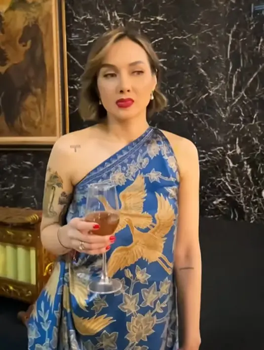 Dress one shoulder dengan latar warna biru navy dan motif batik burung berwarna yellow gold. [@humasjogja]