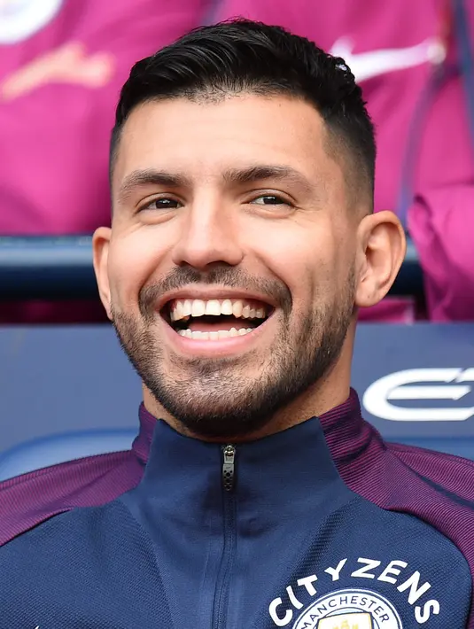 Sergio Aguero tertawa di bangku cadangan saat pertandingan melawan Stoke City di Liga Inggris di Stadion Etihad di Manchester, (14/10). Saat menuju pulang ke Manchester, taksi yang ditumpangi mengalami kecelakaan.  (AFP Photo/Oli Scarff)