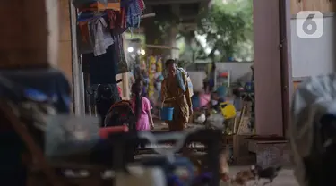 Penjual jamu gendong melintasi permukiman warga di Kawasan Penjaringan, Jakarta, Sabtu (23/11/2019). Bank Dunia mengukur tingkat kemiskinan dengan batas Upper Middle-Income Clas atau kelas menengah mempunyai pendapatan US$ 5,5 atau setara Rp 77 ribu per hari. (merdeka.com/Imam Buhori)