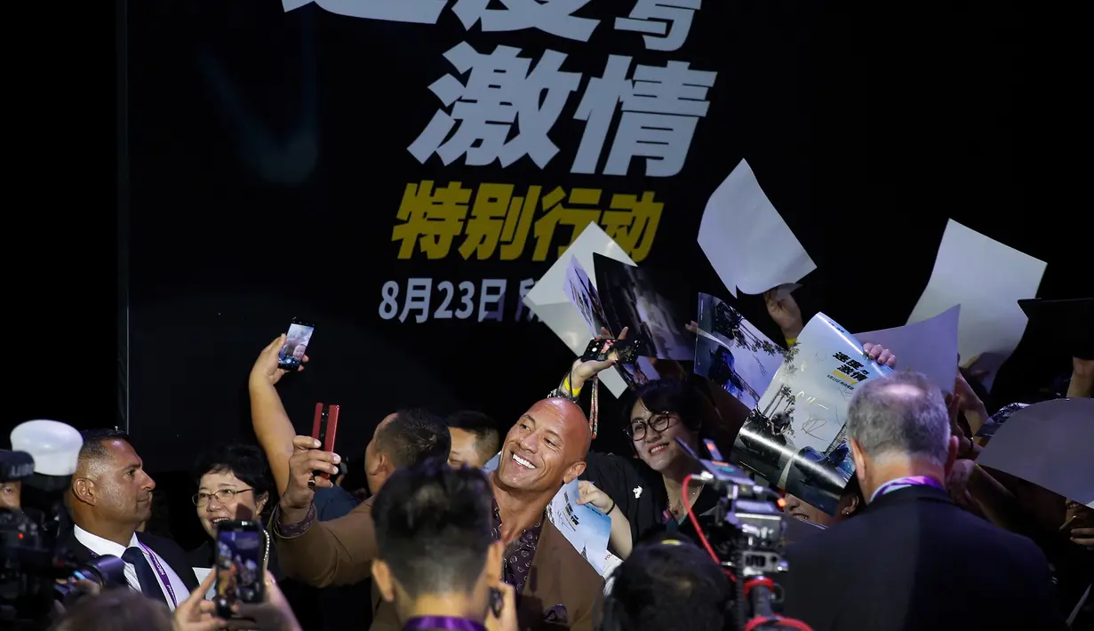 Aktor Dwayne Johnson berswafoto bersama penggemar selama acara red carpet dalam premiere film 'Fast & Furious: Hobbs & Shaw' di Beijing, China, Senin (5/8/2019). Hobbs and Shaw menempatkan dua aktor laga papan atas, Jason Statham dan Dwayne Johnson sebagai pemeran utama. (AP Photo/Andy Wong)