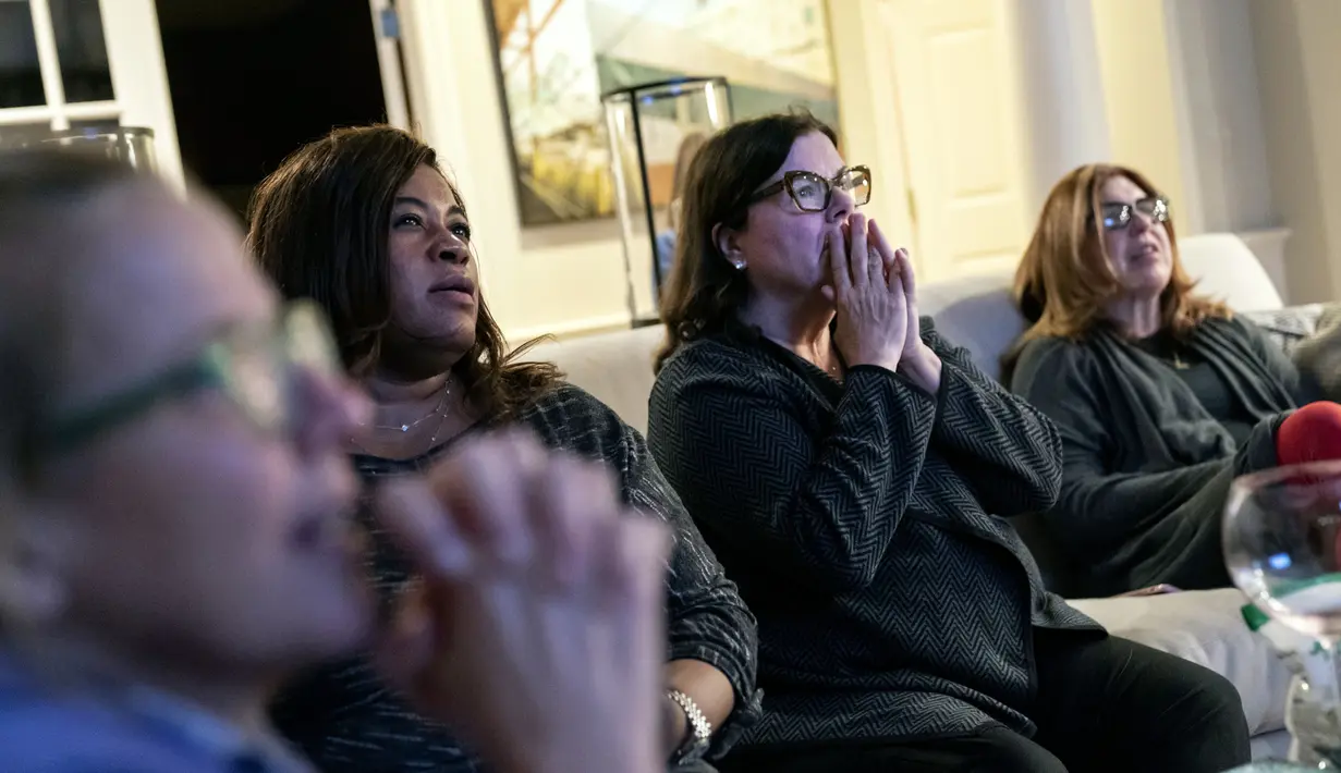 Pendukung calon presiden dari Partai Demokrat Joe Biden, dari kiri, Kimber Bishop-Yanke, Leslie Esters-Redwine, Lori Goldman dan Mimi Miletic, bereaksi terhadap hasil pemilu di pesta pengawas di Bloomfield Hills, Mich (3/11/2020). (AP Photo / David Goldman)