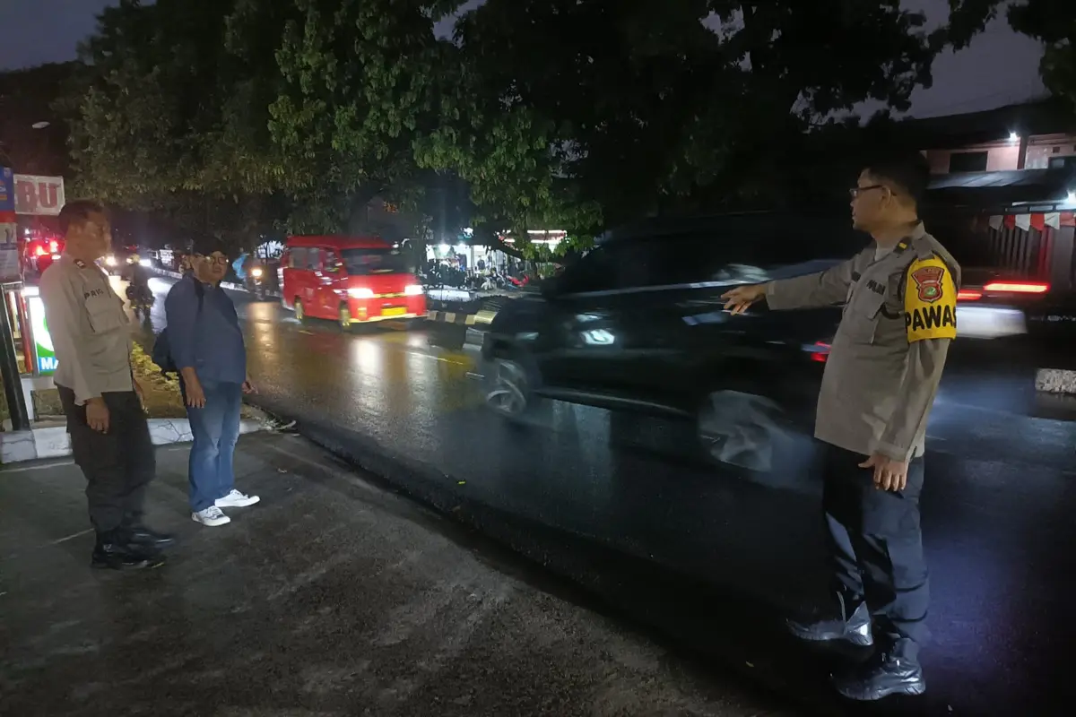Anggota Polsek Sukmajaya mendatangi lokasi peluru nyasar yang mengenai korban di Jalan Proklamasi, Sukmajaya, Kota Depok.