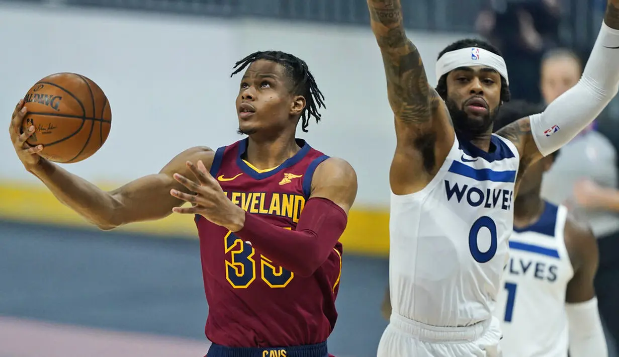 Pebasket Cleveland Cavaliers, Isaac Okoro, berusaha melewati pebasket Minnesota Timberwolves, D'Angelo Russell, pada laga NBA di Rocket Mortgage FieldHouse, Senin (1/2/2021). Cavaliers menang dengan skor 100-98. (AP/Tony Dejak)