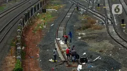 Pekerja menyelesaikan pengerjaan rangkaian rel di Depo Cipinang, Jakarta, Sabtu (16/11/2019). Proyek pembangunan Double-Double Track yang rampung pada awal 2019 masih dalam perbaikan di lajur Depo Cipinang. (merdeka.com/Imam Buhori)