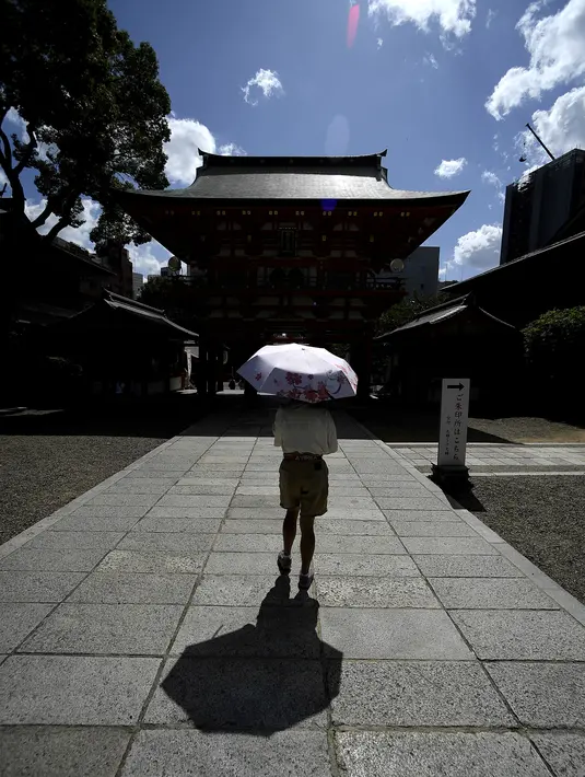 Pengunjung mengenakan payung saat mengunjungi Kuil Ikuta terlihat di pusat Kobe (5/10/2019). Kuil, dengan sejarah lebih dari 1.800 tahun ini dikatakan sebagai salah satu kuil tertua di Jepang. (AFP Photo/Monteforte)