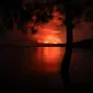 Pemandangan pada 22 Mei 2021 dari Pulau Tchegera di luar Goma di danau Kivu di sebelah timur Republik Demokratik Kongo menunjukkan semburan api dari gunung berapi Nyiragongo. Ahli vulkanologi yang berbasis di Goma, Dario Tedesco, mengatakan retakan baru sedang terbuka di Nyiragongo. (Alex Miles/AFP)