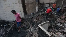 Warga memilah barang-barang yang tersisa di antara puing bangunan pascakebakaran di kawasan permukiman Jalan Kramat Pulo Dalam, Senen, Jakarta Pusat, Jumat (9/10/2026). (KLY/Budy Santoso)