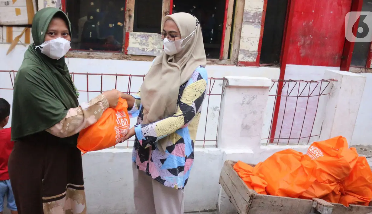 Perwakilan Jurnalis Peduli (kanan) memberikan bantuan paket sembako BNI di Pulau Panggang, Kepulauan Seribu, Kamis (10/9/2022). Paket sembako dan perlengkapan new normal diharapkan dapat membantu warga terdampak pandemi Covid-19 yang saat ini semakin naik. (Liputan6.com/HO/JurnalisPeduli)