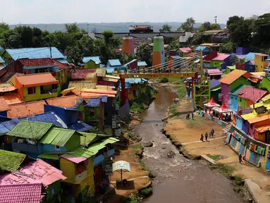 Suasana kampung warna-warni dari atas jembatan yang dipisah oleh Sungai Brantas di Kelurahan Kesatrian, Kota Malang, Minggu (5/11). Ide mengecat kampung ini berawal muncul dari sejumlah mahasiswa UMM. (Liputan6.com/Fery Pradolo)