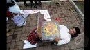 Seorang Seniman saat melakukan aksi teatrikal tidur dibawah kursi di depan Gedung Komisi Pemberantasan Korupsi (KPK), Jakarta, Senin (26/1/2014). (Liputan6.com/Herman Zakharia)