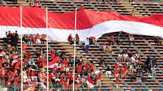 Pendukung Indonesia membentangkan bendera Merah Putih raksasa saat laga kedua Grup A Sepak Bola SEA Games 2023 antara Timnas Indonesia melawan Timnas Myanmar di Olympic Stadium, Phnom Penh, Kamboja, Kamis (04/05/2023). Skuad asuhan Indra Sjafri tersebut berhasil menang dengan skor telak 5-0. (Bola.com/Abdul Aziz)
