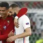 Pemain Portugal Cristiano Ronaldo (kiri) dan pemain Prancis Karim Benzema (kanan) meninggalkan lapangan bersama saat turun minum pada pertandingan Grup F Euro 2020 di Puskas Arena, Budapest, Hungaria, Rabu (23/6/2021). Laga berakhir imbang 2-2. (Franck Fife, Pool photo via AP)