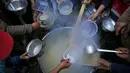 Walid al-Hattab Palestina membagikan sup kepada orang-orang yang membutuhkan selama bulan puasa Ramadhan di tengah pandemi COVID-19 di Kota Gaza (14/4/2021). (AFP/Mohammed Abed)