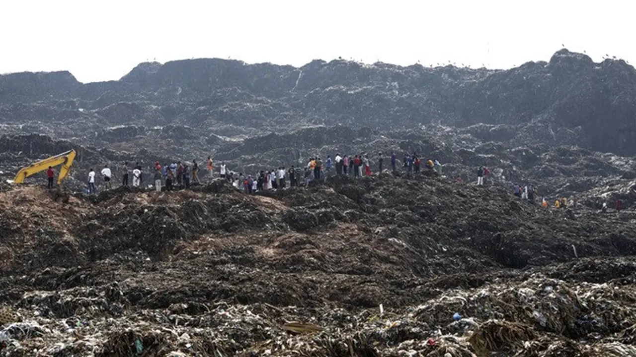 Warga menyaksikan para pekerja mencari korban selamat di lokasi tempat pembuangan sampah yang longsor di Kampala, Uganda, Minggu (11/8/2024).