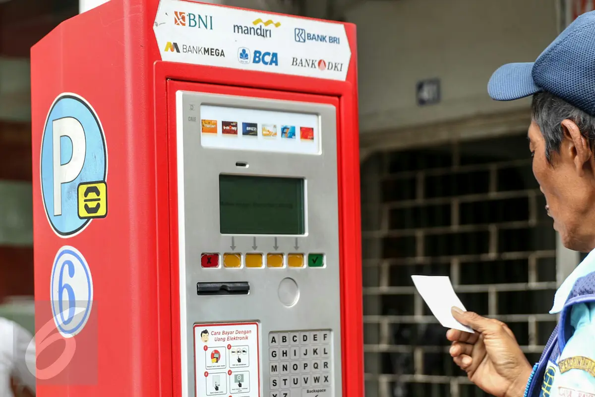 Petugas parkir melakukan transaksi dengan mesin terminal parkir elektronik (TPE) di jalan Sabang, Jakarta, Kamis (25/2). Pemprov DKI Jakarta berencana menambah mesin terminal parkir elektronik (TPE) atau parkir meter. (Liputan6.com/Yoppy Renato)