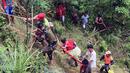 Relawan menggunakan tali untuk mengevakuasi penumpang bus yang terjun ke jurang di Provinsi Nueva Ecija di Filipina Utara, Selasa (18/4). Sekitar 60 penumpang berada dalam bus dengan kapasitas 45 orang. (Philippine Red Cross Nueva Vizcaya chapter via AP)
