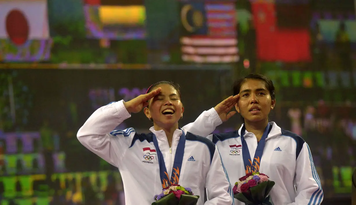 Nitya Krishinda (kanan) dan Gresya Polii menyanyi Indonesia Raya ketika pengibaran bendera merah putih di Gyeyang Gymnasium, Incheon, Korsel, (27/9). (ANTARA FOTO/SAPTONO)