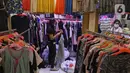 Seorang wanita menata pakaian di kios pakaian bekas Pasar Senen Blok III, Jakarta, Kamis (11/6/2020). Pasar yang tetap buka saat PSBB dengan pembatasan jam operasional ini akan kembali dibuka secara normal pada 15 Juni 2020 dengan aturan protokol kesehatan COVID-19. (Liputan6.com/Herman Zakharia)