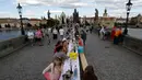 Warga menggelar makan malam di atas meja sepanjang 500 meter di jembatan bersejarah Charles Bridge di Praha, Republik Ceko, Selasa (30/6/2020). Kegiatan itu merupakan perpisahan simbolis yang digelar untuk menandai akhir dari masa krisis virus corona Covid-19 di negara tersebut (AP/Petr David Josek)