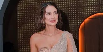 Luna Maya hadir dengan model lehenga modern dengan siluet dress strapless model heart neck dihiasi dupatta atau selendang panjang dengan warna nude dihiasi beads silver. Kalung model silver tampa liontin. Sambil membawa handbag hitam salur silver. Rambut pendeknya ditata wavy. [@lunamaya]