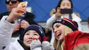 Putri Presiden AS Donald Trump yang juga penasihat senior Gedung Putih, Ivanka Trump (kanan) berswafoto dengan atlet Korea Selatan saat menonton snowboard pria pada Olimpiade Musim Dingin Pyeongchang 2018, Korea Selatan, Sabtu (24/2). (Ed JONES/AFP)