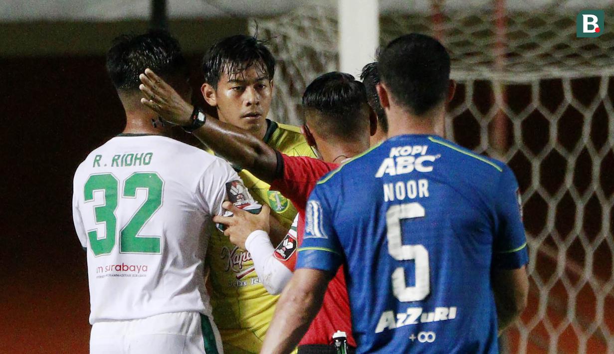 Kiper Persebaya Surabaya, Satria Tama (tengah) diusir wasit Agus Fauzan Arifin usai mendapat kartu merah dalam laga perempatfinal Piala Menpora 2021 di Stadion Maguwoharjo, Sleman, Minggu (11/4/2021). (Bola.com/M Iqbal Ichsan)