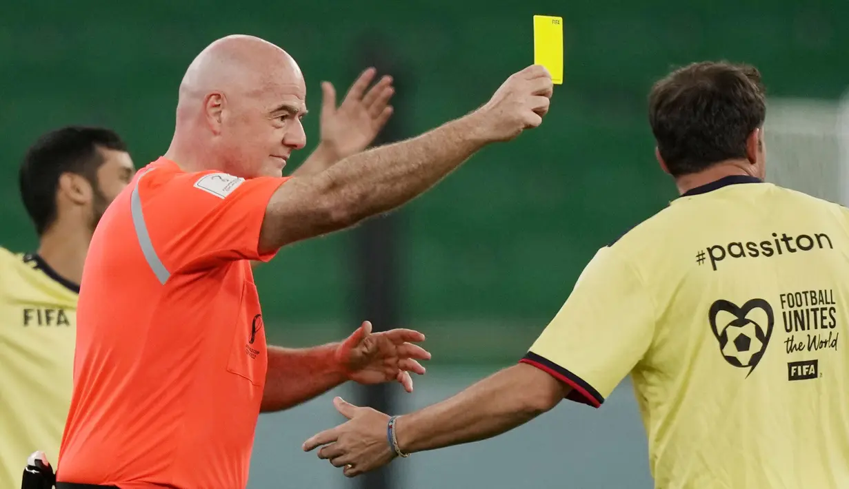 Presiden FIFA, Gianni Infantino, memberikan kartu kuning kepada Alessandro Del Piero pada laga hiburan jelang semi final Piala Dunia di Stadion Al Thumama, Senin (12/12/2022). (AP Photo/Frank Augstein)