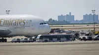 Petugas tanggap darurat berkumpul di luar pesawat setelah penumpang Emirates Airline dilaporkan jatuh sakit di Bandara Kennedy New York, Rabu (5/9). Sekitar 100 dari total 500 penumpang pesawat dari Dubai itu mengeluh sakit dan demam. (AP/Bebeto Matthews)