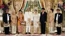 Presiden Joko Widodo (Jokowi) didampingi Ibu Negara, Iriana Joko Widodo berfoto bersama pada pernikahan putri Ketua DPD, Oesman Sapta Odang di kawasan Kuningan, Jakarta, Jumat (8/9). (Liputan6.com/Johan Tallo)