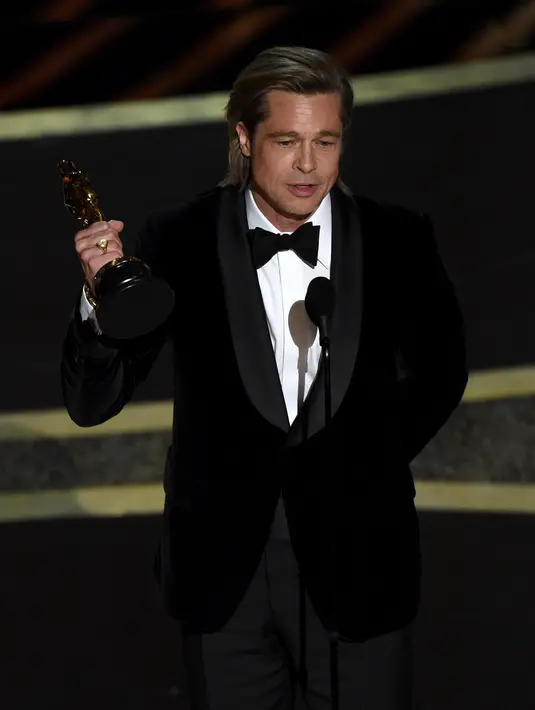 Kali Pertama Brad Pitt Menang Oscar: Brad Pitt menyampaikan pidato saat menerima piala Oscar sebagai Aktor Pendukung Terbaik di atas panggung Academy Awards  di Dolby Theatre, Los Angeles, Minggu (9/2/2020). Brad Pitt untuk aktingnya di film Once Upon a Time in Hollywood. (AP/Chris Pizzello)