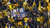 Suporter Maccabi mengibarkan bendera kuning di samping bendera Israel selama pertandingan Liga Europa, pekan ke-4, antara Ajax Amsterdam dan Maccabi Tel Aviv di Stadion Johan-Cruijff, Amsterdam, pada 7 November 2024. (Robin van Lonkhuijsen/ANP/AFP)