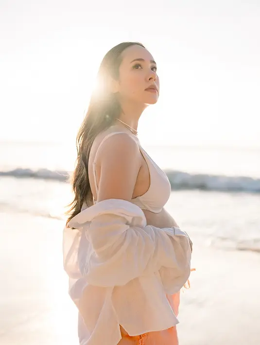 Dengan rambut panjang yang tergerai, Pamela Bowie memamerkan pesona bumil glowing yang flawless [@pammybowie]