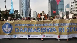Ratusan mahasiswa internasional mengenakan pakaian adat Indonesia sambil membawa spanduk saat pawai kelulusan beasiswa Kemendikbud di car free day (CFD), Jakarta, Minggu (6/5). (Merdeka.com/Iqbal Nugroho)