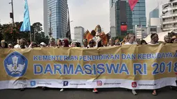 Ratusan mahasiswa internasional mengenakan pakaian adat Indonesia sambil membawa spanduk saat pawai kelulusan beasiswa Kemendikbud di car free day (CFD), Jakarta, Minggu (6/5). (Merdeka.com/Iqbal Nugroho)