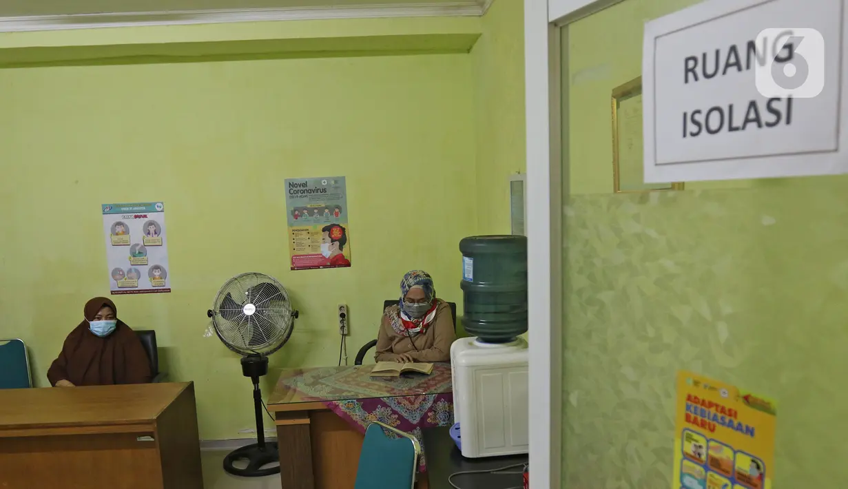Guru sedang berjaga di ruang isolasi  SMKN 51, Jakarta, Rabu (7/4/2021). Para murid diwajibakan membawa makanan sendiri  dan mengikuti syarat & panduan sekolah tatap muka seperti membuka pintu dan jendela.(Liputan6.com/Herman Zakharia)
