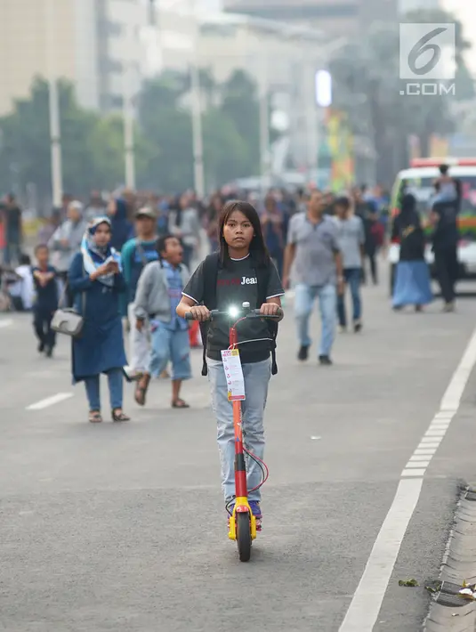 Seorang anak menaiki skuter di sekitar panggung Jakarta Night Festival di Bundaran HI, Jakarta, Sabtu (22/6/2019). Warga yang hadir dalam malam puncak HUT ke-492 Jakarta diperkenankan menaiki skuter listrik tersebut dengan gratis. (merdeka.com/Imam Buhori)